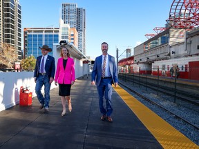 From left; Jim Laurendeau, Calgary Stampede vice president, park planning; development, Kate Thompson, CMLC president and CEO and Chris Jordan, Calgary Transit manager service design, walk on a temporary platform that will be in use while the final demolition of the Stampede Park CTrain station takes place.