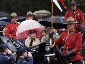 Despite heavy rain, Queen Elizabeth II and the Duke of Edinburgh ride an open Landau to the official welcome to Canada and Saskatchewan at the legislature in Regina.