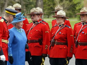 Queen Elizabeth inspects members of the RCMP at Depot Division in Regina. She placed a wreath at the cenotaph in memory of the four RCMP officers killed earlier that year.