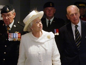 Queen Elizabeth II, accompanied by The Duke of Edinburgh, tours the Princess Patricia’s Canadian Light Infantry gallery at the Museum of the Regiments in Calgary. She was escorted by Major General Robert Stewart, left, the Colonel of the Regiment. Calgary Herald archives