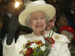 Her Royal Highness Queen Elizabeth II waves to the performers at the Pengrowth Saddledome.