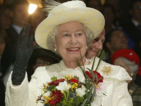 Queen Elizabeth II waves to the performers at the Saddledome. Calgary Herald archives