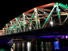 FILE - The Reconciliation Bridge is lit in red and green  on the evening of Monday, September 28, 2020. Calgary reversed a decision to light the bridge up blue in honour of Queen Elizabeth II after consulting with the Indigenous community.
