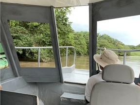 The captain pilots his riverboat down the Tempisque River in Hacienda El Viejo Wetlands searching for crocodiles.