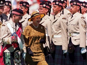 Queen Elizabeth II walks with Lt. Col. A.G. Maitland as she inspects the guard of Calgary Highlanders June 30, 1990 in Calgary. Canadian Press photo