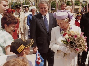 Queen Elizabeth II, accompanied by Prime Minister Brian Mulroney, chats with a small boy in Calgary, June 28, 1990.