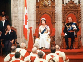 With Prime Minister Pierre Trudeau, left, and Prince Philip beside her, Queen Elizabeth II officially opens a session of Parliament in Ottawa on Oct. 18, 1977.