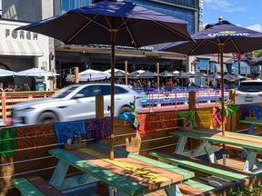 Traffic zips by patios on 17th Avenue S.W. on Friday, Aug. 5, 2022.