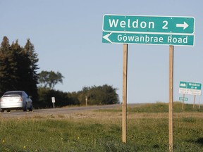 A vehicle drives past the road sign for Weldon, Sask., on Tuesday, Sept. 6, as a manhunt continues for stabbing suspect Myles Sanderson.