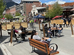 Busy Banff Avenue with open patios and visitors on Saturday night, June 12, 2021.
