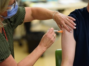 A registered nurse administers a flu shot at the Richmond Road Diagnostic and Treatment Centre on Monday, October 17, 2022.