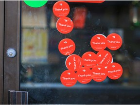 Glass damage covered by stickers is seen on the front door of TJ's Pizza on Centre St. North on Thursday, October 20, 2022.