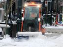 A worker is seen plowing snow from Stephen Avenue after an overnight snowfall on Wednesday, February 16, 2022.