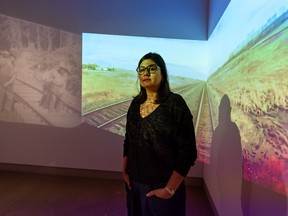 Kanika Anand, associated curator at Contemporary Calgary, poses for a photo in front of Jeannie Mah's Train: Les Arrivee, which is part of the exhibit Human Capital. The 12-artist group exhibit was curated by Tak Pham, Associated curator at the MacKenzie Art Gallery in Regina.