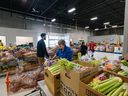 Volunteers put together hampers of fresh and canned foods at the Calgary Food Bank on Wednesday, October 26, 2022.