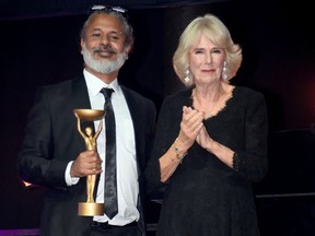 Camilla, Queen Consort poses with winner Shehan Karunatilaka for The Seven Moons of Maali Almeida at the Booker Prize for Fiction 2022 awards ceremony at the Roundhouse, on October 17, 2022, in London, England.
