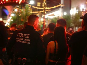 Members of the Calgary Police Violent Crime Suppression Team (formerly the Gang Suppression Unit) visit and chat with citizens at a popular nightclub on Stephen Ave. in downtown Calgary on June 17, 2022.