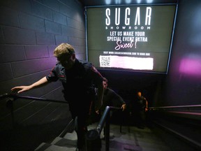 Members of the Calgary Police Violent Crime Suppression Team (formerly the Gang Suppression Unit) are joined by officers as they do a walkthrough at a basement strip club on 7 Ave. SW in downtown Calgary on June 18, 2022.