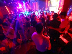 Members of the Calgary Police Violent Crime Suppression Team (formerly the Gang Suppression Unit) walk through a jam-packed basement nightclub on 1 St. SW in downtown Calgary on June 18, 2022.