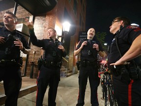 Members of the Calgary Police Violent Crime Suppression Team (formerly the Gang Suppression Unit) come up with a game plan before entering a popular nightclub on 10 Ave. SW in downtown Calgary on June 18, 2022.