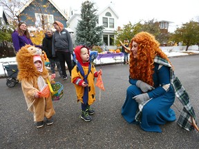 Twins Connor and Emily Petruska, 2, meet the character Merida from the Disney movie Brave during an accessible and inclusive trick-or-treating experience for children with disabilities on 10A St. NW in Kensington in Calgary on Sunday, October 23, 2022.