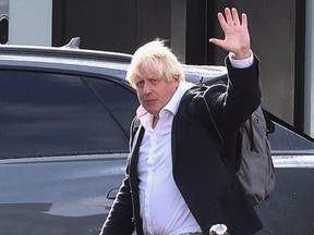 Former British Prime Minister Boris Johnson gestures, at Gatwick Airport, near London, Saturday, Oct. 22, 2022.