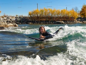 Ulian Shahnovich takes advantage of another warm October afternoon to get in some river surfing in Harvie Passage on Monday, October 17, 2022.