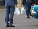 FILE PHOTO: Shoppers leave a store in Marlborough with groceries in plastic bags on Wednesday, October 7, 2020.