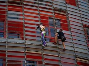 French skyscraper climber Alain Robert (L), known as the French Spiderman, climbs the Glorias Tower with his son Will in Barcelona on October 1, 2022.