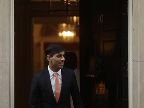 In this file photo, British newly appointed Chancellor of the Exchequer Rishi Sunak leaves 10 Downing Street, where he was given the job by Britain's Prime Minister Boris Johnson, in London, Feb. 13, 2020.
