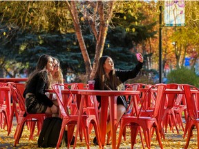 Friends pose for a photo in Tomkins Park during a sunny lunch hour in Calgary beltline on Tuesday, October 18, 2022. 
Gavin Young/Postmedia.