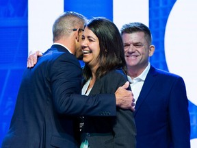 Travis Toews hugs Danielle Smith prior to her speech as Brian Jean watches at UCP annual general meeting on Saturday at the River Cree Resort and Casino.