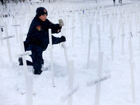 Jack Koops from the Calgary Police Cadet Corp. was among teams of Volunteers (groups and individuals) gathered for the 14th year, to set up the display of 3,620 white crosses for the Field of Crosses Memorial Display along Memorial Drive in Calgary on Saturday, October 22, 2022.