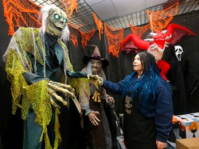 Sales associate Karissa Porterfield displays some of this year's most popular items at Halloween Alley in Beacon Hill.