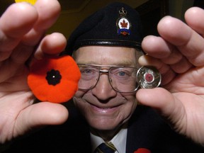 On this day in 2004, the Royal Canadian Mint unveiled the world's first coloured circulation coin, a quarter that featured a red poppy embedded in the centre of a Maple Leaf, in homage to the 117,000 Canadians who had died serving the nation. Pictured,
Harvey Shevalier, first vice-president of the Royal Canadian Legion Alberta N.W.T. Command displays a poppy and one of the Canadian poppy quarters. Postmedia archives.