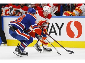 Sep 30, 2022; Edmonton, Alberta, CAN; Calgary Flames forward Connor Zary (47) looks to cary the puck around Edmonton Oilers defensemen Ryan Murray (28) during the second period at Rogers Place. Mandatory Credit: Perry Nelson-USA TODAY Sports