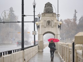 A pedestrian crosses the Centre Street bridge as snow begins to fall in Calgary on Tuesday.