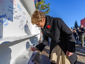 Mayor Jyoti Gondek signs the steel beam before it is lifted into place on Thursday.
