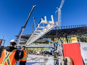 The final steel beam is lifted into place at the BMO expansion project on Thursday.