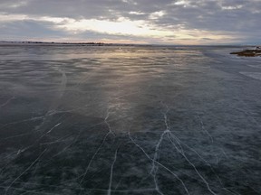 The thin ice on McGregor Lake shines in the morning sun near Milo, Ab., on Tuesday, November 22, 2022.