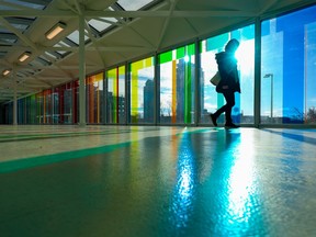 Pedestrians walk through the multi-coloured panels of the Plus-15 from City Hall to Arts Commons on Nov. 14, 2022.