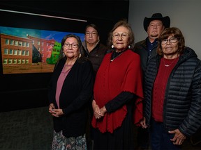 Angeline Ayoungman, residential school survivor and member of the Old Sun Community College Advisory Committee, left, Herman Yellow Old Woman, residential school survivor and member of the Old Sun Community College Advisory Committee, Dr. Vivian Ayoungman-Baumont, residential school survivor and member of the Old Sun Community College Advisory Committee and Siksika Studies Consultant, Dr. Ceremonial valedictorian Kent Ayoungman and Principal Gwendora Bear, residential school survivor and member of the Old Sun Community College Advisory Committee, pose for a photo with a presentation of the Digital Preservation of Indian Residential Schools Project in the background at the University of Calgary on Thursday, November 24, 2022.