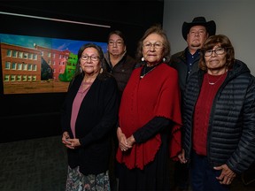 Angeline Ayoungman, residential school survivor and member of the Old Sun Community College Advisory Committee, left, Herman Yellow Old Woman, residential school survivor and member of the Old Sun Community College Advisory Committee, Dr.  Vivian Ayoungman-Baumont, residential school survivor and member of the Old Sun Community College Advisory Committee and Siksika Studies Consultant, Dr.  Ceremonial valedictorian Kent Ayoungman and Principal Gwendora Bear, residential school survivor and member of the Old Sun Community College Advisory Committee, pose for a photo with a presentation of the Digital Preservation of Indian Residential Schools Project in the background at the University of Calgary on Thursday, November 24, 2022.