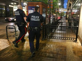 Members of the Calgary Police Force's Violent Crime Suppression Team enter a restaurant on Stephen Avenue in downtown Calgary on June 17, 2022.