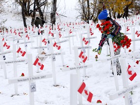 Student Malaea Dennis, 9, from Delta West Academy along with teachers, students and their families continued their 10-plus year tradition of placing red poppies on the crosses at the Field of Crosses along Memorial Drive in Calgary on Sunday, October 23, 2022.