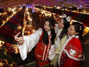 Left to right, Shuxin Wang, Lydia Li and Mia Wang from the Calgary Hanfu Society take a selfie at the Spruce Meadows International Christmas Market. The market was ranked in the top 5 in the world. Photo taken in Calgary on Sunday, November 20, 2022.