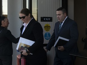 Const. Jessica Brown and Cpl. Randy Stegner, right, leave court in Edmonton on Monday, Nov. 21, 2022. Brown and Stegner of the Whitecourt RCMP are charged with manslaughter in the 2018 death of Clayton Crawford, as well as aggravated assault.