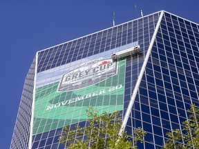 A crew puts the finishing touches on a 2022 Grey Cup banner in downtown Regina.