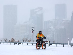 A cyclist braves the cold and snow in central Calgary on Monday.