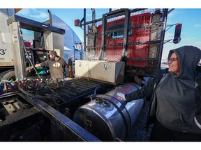 Jordan Hazelwood, left, and Lyndsie McCann fill up their semi truck at the Road King truck stop in Calgary on Monday, Nov. 14, 2022. Record high diesel prices have been seen across the country.